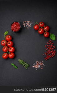 Ingredients for cooking cherry tomatoes, salt, spices and herbs on a dark concrete background