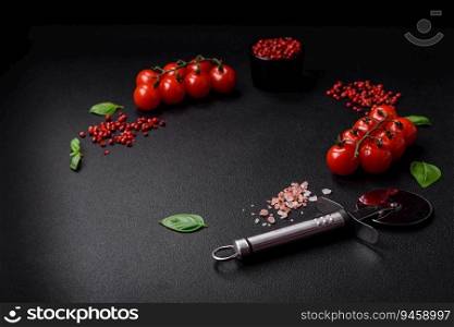 Ingredients for cooking cherry tomatoes, salt, spices and herbs on a dark concrete background
