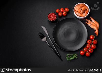 Ingredients for cooking cherry tomatoes, shrimp, salt and spices with a place for an inscription on a dark concrete background. Ingredients for cooking cherry tomatoes, shrimp, salt and spices