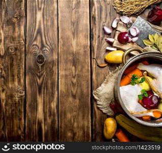 Ingredients for cooking chicken soup with vegetables and spices. On a wooden table.. Ingredients for cooking chicken soup with vegetables and spices.