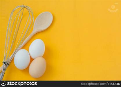 Ingredients for cooking, eggs and kitchen tools on a wooden table top view. Recipes with three eggs.. Ingredients for cooking, eggs and kitchen tools on a wooden table top view.