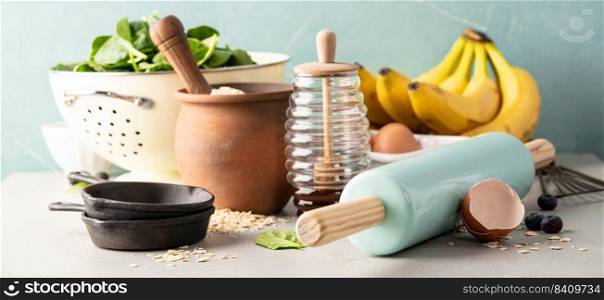 Ingredients for cooking spinach or banana pancakes or baking spinach or banana muffins- oats,  bananas, rolling pin, eggs, spinach, honey