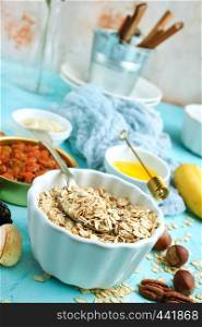 ingredients for helthy breakfast, raw oat flakes with banana and nuts