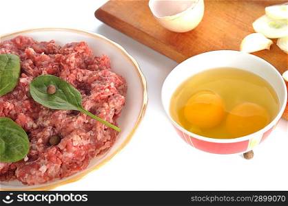 Ingredients for homemade cutlet, ground beef, onion, eggs and garlic.