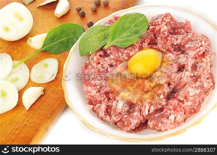 Ingredients for homemade cutlet, ground beef, onion, eggs, pepper, and garlic.