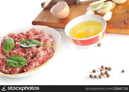 Ingredients for homemade cutlet, ground beef, onion, eggs, pepper, and garlic.