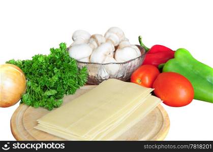 Ingredients for lasagna - tomatoes, pepper, parsley, mushrooms, onion, pasta on white background