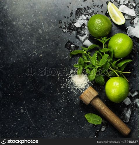 Ingredients for making mojitos (ice cubes, mint leaves, sugar and lime on rustic background)