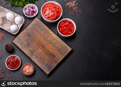Ingredients for making shakshuka, dishes with fried eggs with tomato sauce, sweet pepper, garlic, onions, spices and herbs. Hearty and delicious breakfast. Ingredients for making shakshuka, dishes with fried eggs with tomato sauce, spices and herbs