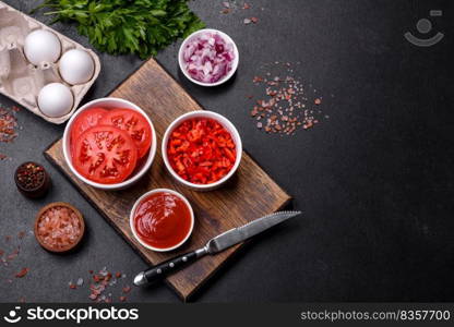 Ingredients for making shakshuka, dishes with fried eggs with tomato sauce, sweet pepper, garlic, onions, spices and herbs. Hearty and delicious breakfast. Ingredients for making shakshuka, dishes with fried eggs with tomato sauce, spices and herbs