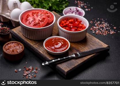 Ingredients for making shakshuka, dishes with fried eggs with tomato sauce, sweet pepper, garlic, onions, spices and herbs. Hearty and delicious breakfast. Ingredients for making shakshuka, dishes with fried eggs with tomato sauce, spices and herbs