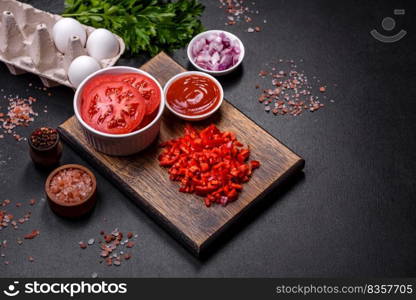 Ingredients for making shakshuka, dishes with fried eggs with tomato sauce, sweet pepper, garlic, onions, spices and herbs. Hearty and delicious breakfast. Ingredients for making shakshuka, dishes with fried eggs with tomato sauce, spices and herbs