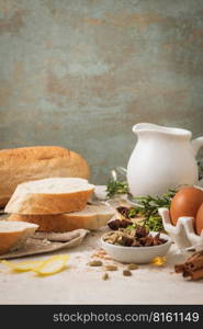 Ingredients for preparing spanish torrijas, french toasts  or traditional Portuguese rabanadas for Christmas. Typical sweet food for Christmas made with slices of bread, eggs, cinnamon, milk and lemon