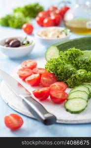 ingredients for salad with tomatoes cucumber olives and feta cheese