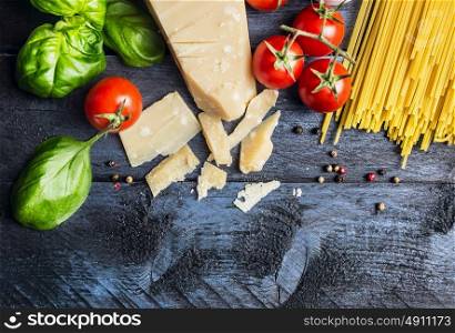 Ingredients for spaghetti with tomato sauce: basil, tomatoes,parmesan on blue wooden background , top view,place for text