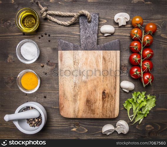 ingredients for the salad, oil, cherry tomatoes, lettuce, spices on wooden rustic background top view close up place for text,frame
