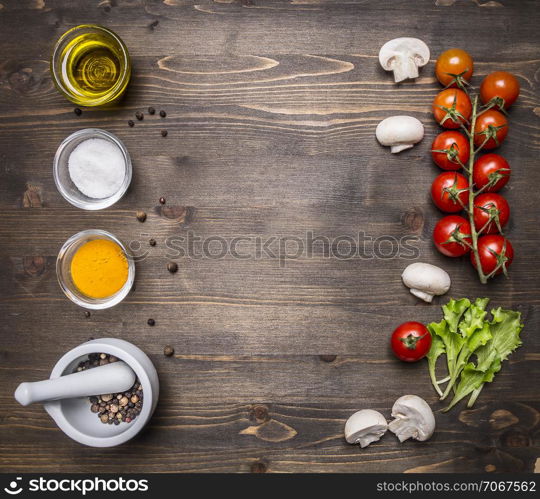 ingredients for the salad, oil, cherry tomatoes, lettuce, spices on wooden rustic background top view close up place for text,frame