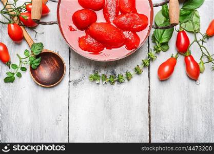 Ingredients for tomato sauce - fresh and peeled tomatoes, basil and spoon on white wooden background, top view, border.