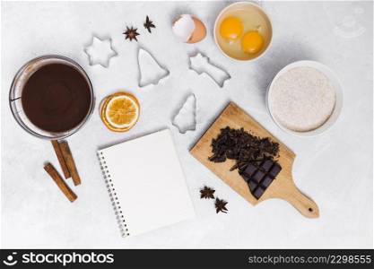 ingredients making homemade cake with spiral notepad pastry cutters white background