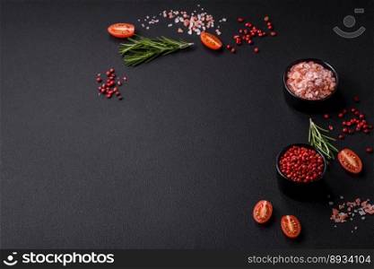 Ingredients salt, spices, herbs and tomatoes on a dark concrete background. Cooking at home