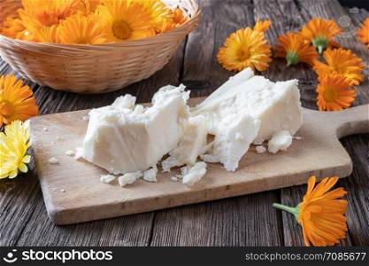 Ingredients to parepare a homemade calendula ointment - raw unrefined shea butter and fresh marigold flowers