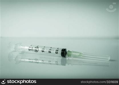 Injection syringe on a clean grey background. Syringe on grey background