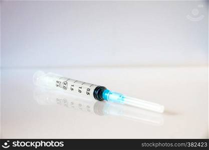 Injection syringe on a clean grey background. Syringe on grey background