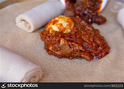Injera served with Chicken and egg Doro Wat. Injera is a sourdough flatbread made from teff flour. It is the national dish of Ethiopia, Eritrea, Somalia and Djibouti