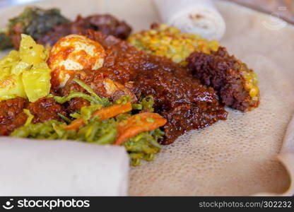 Injera served with Chicken and egg Doro Wat, berbere, vegetables and lentils. Injera, the national dish of Ethiopia, is a sourdough flatbread made from teff flour.