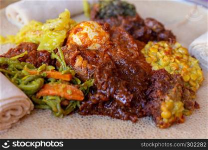 Injera served with Chicken and egg Doro Wat, berbere, vegetables and lentils. Injera, the national dish of Ethiopia, is a sourdough flatbread made from teff flour.