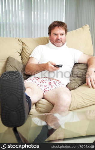 Injured man at home on the couch, wearing a foot brace and neck collar.