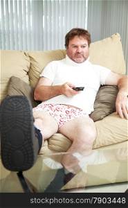 Injured man at home on the couch, wearing a foot brace and neck collar.