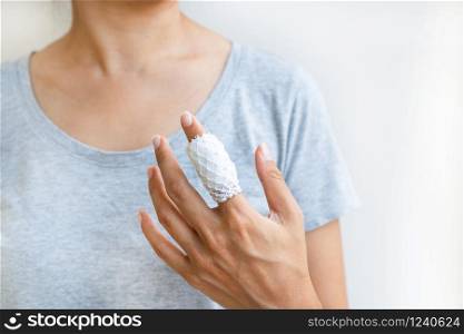 Injured painful finger with white gauze bandage