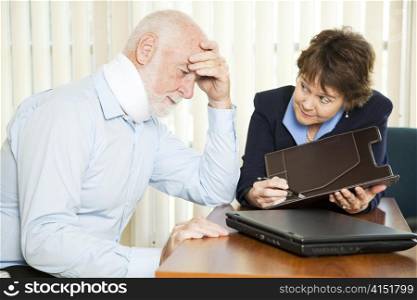 Injured senior man and his accountant worrying about the cost of medical bills.