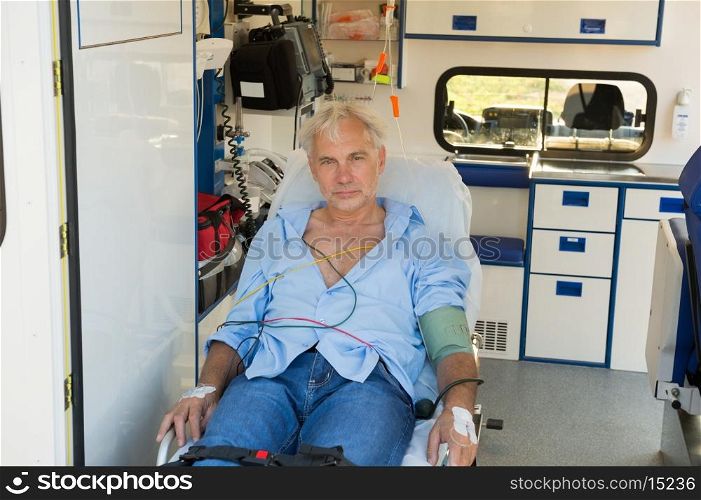Injured senior man sitting on stretcher in ambulance car
