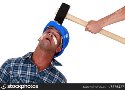 Injured tradesman being hit over the head with a mallet