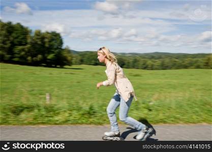 Inline skating young woman speed workout sunny asphalt road