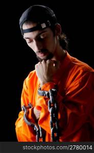 Inmate chained on black background