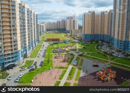 Inner yard among modern apartment buildings in residential district of Saint Petersburg, children playground, car parking, view from above, Russia