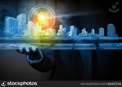 Innovation concept. Businessperson holding media image of city in palm. New technologies