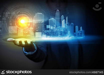 Innovation concept. Businessperson holding media image of city in palm. New technologies