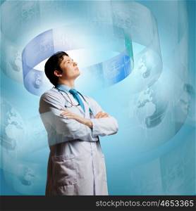 Innovation technologies. Image of young thoughtful doctor looking at media screen