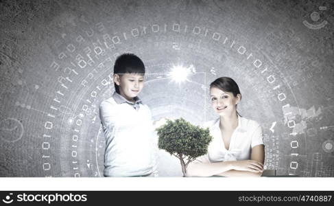 Innovation technologies in education. Woman teacher and boy at lesson touching media screen