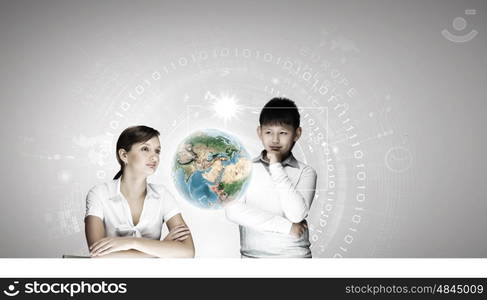 Innovation technologies in education. Woman teacher and boy at lesson touching media screen. Elements of this image are furnished by NASA