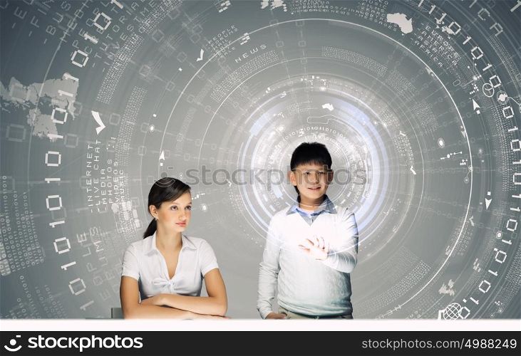 Innovation technologies in education. Woman teacher and boy at lesson touching media screen