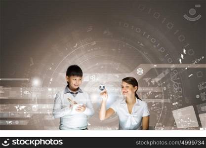 Innovation technologies in education. Woman teacher and boy at lesson touching media screen