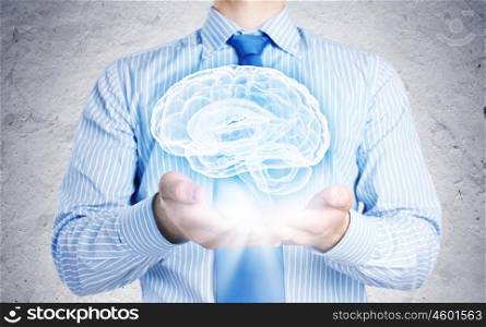 Innovations in medicine. Close up of businessman holding image of brain in hands
