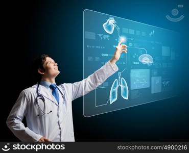 Innovations in medicine. Young male doctor touching icon on media screen