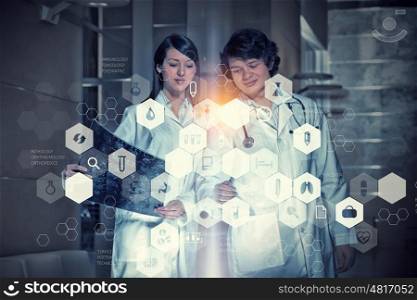 Innovative technologies in medicine. Two young doctors working with media screen