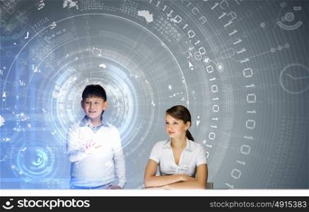 Innovative technologies lesson. Young teacher and school boy at computing lesson